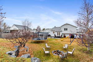 View of yard with a trampoline and a playground