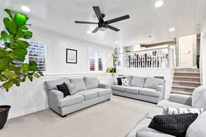 Carpeted living room with ceiling fan and wood ceiling