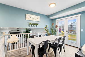 Dining area with french doors and light wood-type flooring