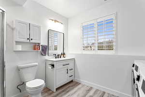 Bathroom featuring wood-type flooring, vanity, and toilet