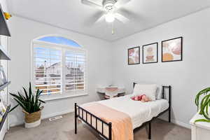 Carpeted bedroom with ceiling fan