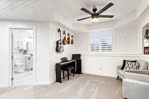 Living area with wood ceiling, ceiling fan, and light colored carpet