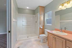 Bathroom featuring a shower, vanity, and toilet