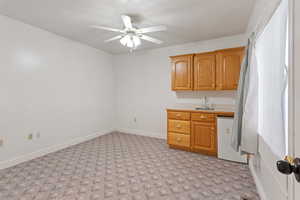 Kitchen featuring dishwashing machine, ceiling fan, and sink