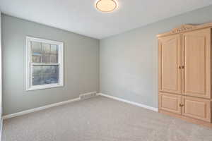 Empty room featuring light colored carpet