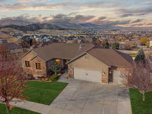 View of front of house featuring a mountain view, a yard, and a garage