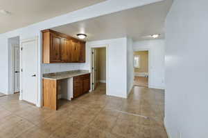 Kitchen featuring light stone countertops and built in desk