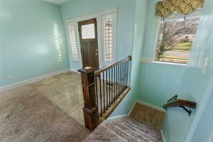 Stairs featuring a wealth of natural light and carpet floors