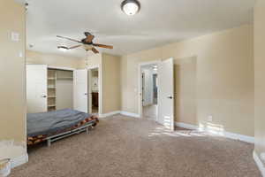 Unfurnished bedroom with ceiling fan, light carpet, and a closet