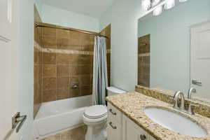 Full bathroom with shower / bath combo, vanity, and toilet