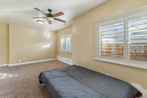 Carpeted bedroom with ceiling fan