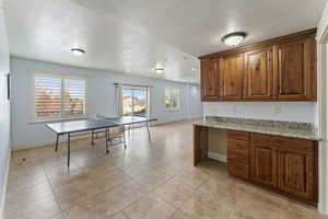 Kitchen with light stone countertops, a healthy amount of sunlight, and a textured ceiling