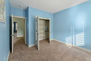 Unfurnished bedroom with a closet and light colored carpet