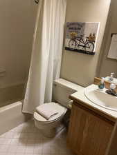 Full bathroom featuring tile patterned flooring, vanity, shower / bath combination with curtain, and toilet