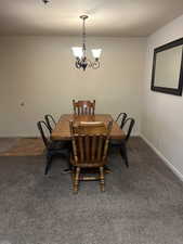 Dining area with a notable chandelier and dark carpet