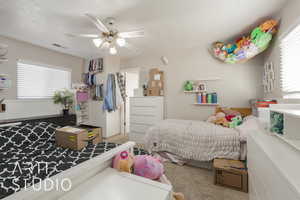 Bedroom featuring carpet, ceiling fan, a textured ceiling, and multiple windows