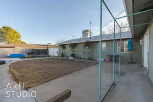 Back of property with cooling unit and a patio