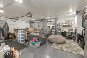 Garage with a workshop area, a garage door opener, and a wall mounted AC