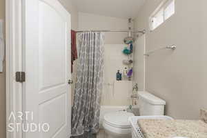 Bathroom featuring shower / tub combo and toilet