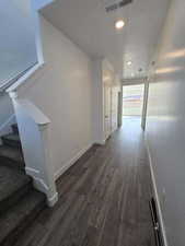 Hallway featuring dark hardwood / wood-style flooring and a textured ceiling