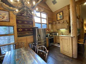 Kitchen featuring sink, stainless steel appliances, dark hardwood / wood-style floors, a chandelier, and decorative backsplash