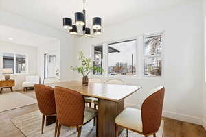 Dining space with a notable chandelier, plenty of natural light, and hardwood / wood-style flooring