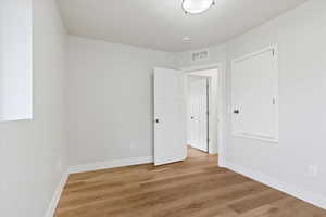 Empty room with light hardwood / wood-style floors