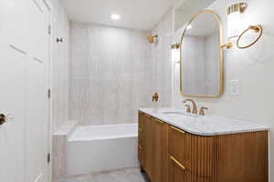 Bathroom with tile patterned flooring, vanity, and tiled shower / bath combo