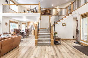 Staircase with hardwood / wood-style floors and a high ceiling