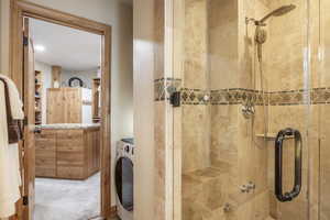 Bathroom featuring an enclosed shower and washer / clothes dryer