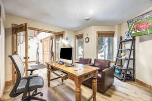 Office area featuring a textured ceiling and light wood-type flooring