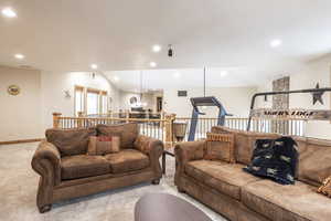 Living room featuring light carpet and vaulted ceiling