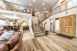 Foyer entrance featuring a towering ceiling and light wood-type flooring