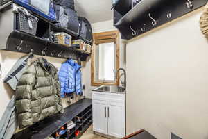 Mudroom featuring light hardwood / wood-style floors, sink, and a textured ceiling