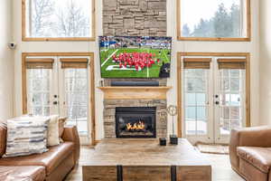 Living room featuring a fireplace, french doors, and a wealth of natural light