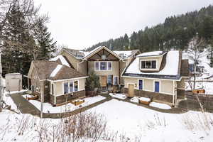 Snow covered rear of property featuring a storage shed