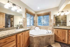 Bathroom with vanity, tile patterned floors, and independent shower and bath