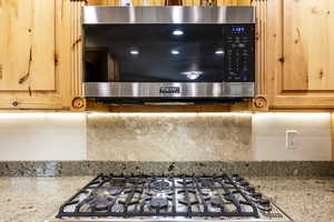 Interior details with stove, backsplash, and light stone counters