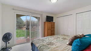 Bedroom with access to exterior, carpet, and two closets