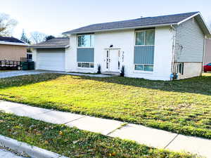 View of front of property with a garage and a front yard