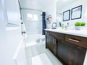 Upstairs Full bathroom featuring tile patterned flooring, shower / bath combination with curtain, vanity, and toilet