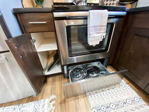 Upstairs Kitchen details with light wood-type flooring and dark brown cabinetry