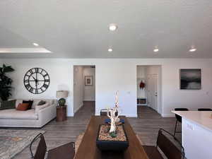 Living room featuring a textured ceiling and dark wood-type flooring