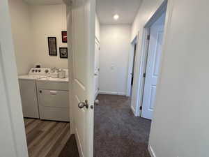 Hall featuring washer and dryer and dark carpet