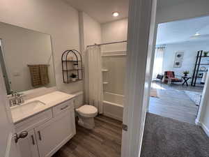 Full bathroom featuring toilet, shower / tub combo with curtain, vanity, and hardwood / wood-style flooring