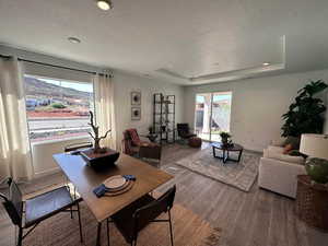 Dining room with a tray ceiling, a mountain view, hardwood / wood-style floors, and a textured ceiling