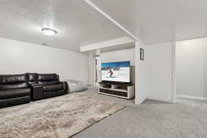 Living room with carpet flooring and a textured ceiling