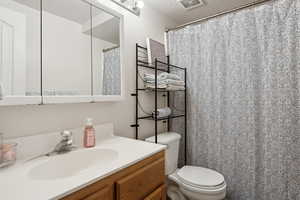 Bathroom with vanity, toilet, and a textured ceiling