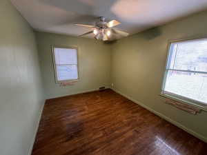 Spare room with ceiling fan, dark wood-type flooring, and a textured ceiling