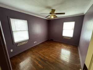 Spare room featuring ceiling fan, dark hardwood / wood-style flooring, and crown molding